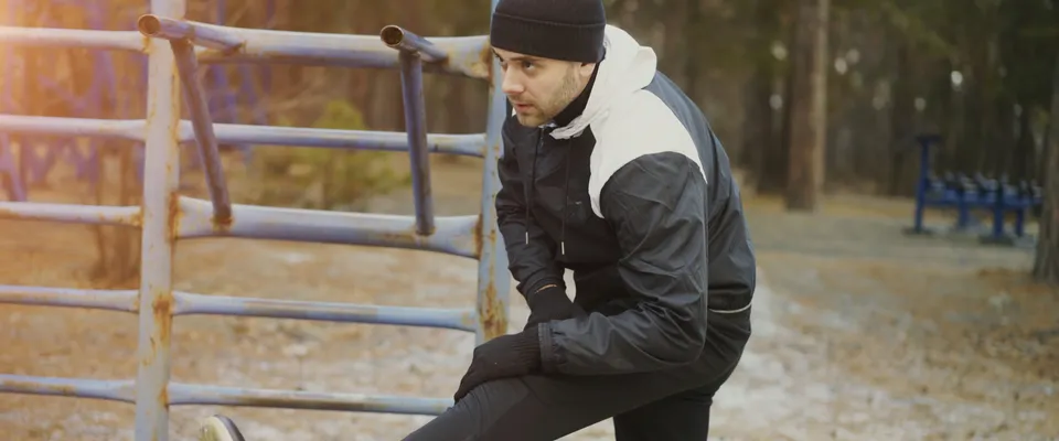 Person stretching legs on outdoor equipment before a walk