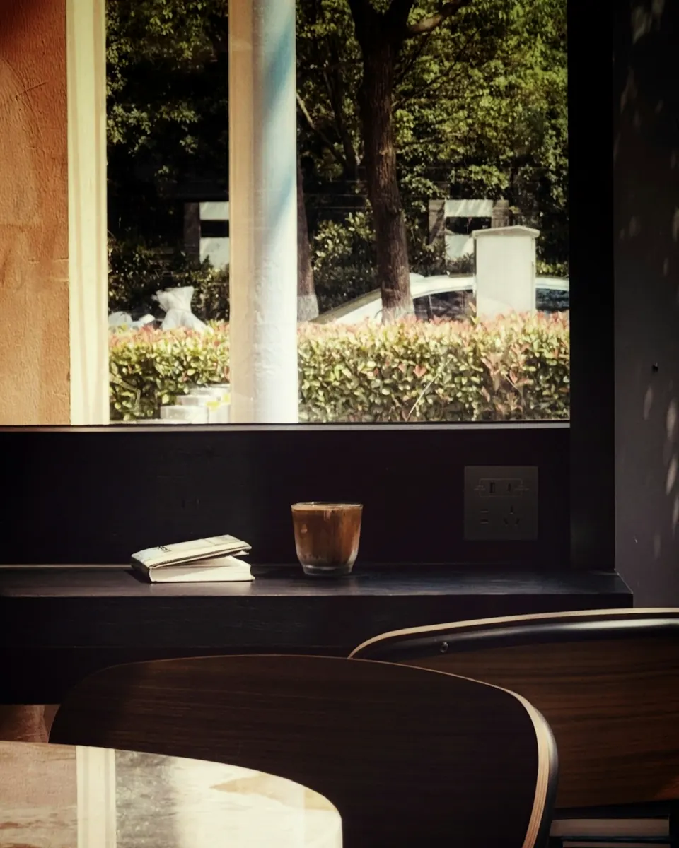 Coffee and books on a table by a bright window
